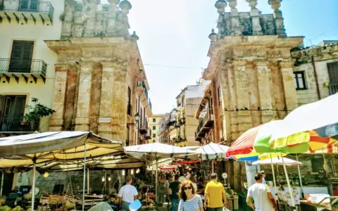 Mercato vivace a Palermo, tra bancarelle colorate e antiche architetture. Un'ottima idea per le cose da fare a Palermo, tra sapori e storia.