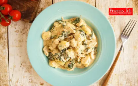 Pyszne gnocchi z kurczakiem i szpinakiem w kremowym sosie, posypane parmezanem. Idealne danie na obiad.