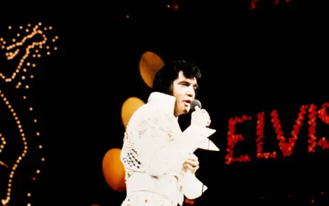 Elvis Presley singt in Hawaii, sein Name leuchtet in roten Lichtern.