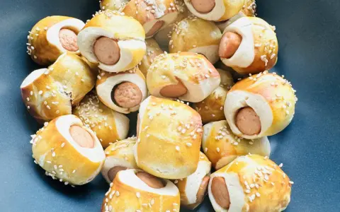 Leckere Würstchen im Teigmantel, bestreut mit Sesam. Perfekt als Fingerfood für eine Babyparty, diese Rezepte sind ein Hit!