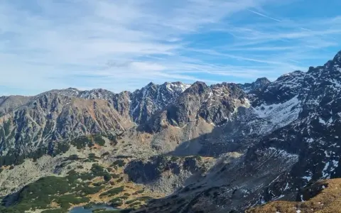 Majestatyczne Tatry z ośnieżonymi szczytami. Widok na skaliste zbocza i doliny, gdzie widać, ile ma Kasprowy Wierch.