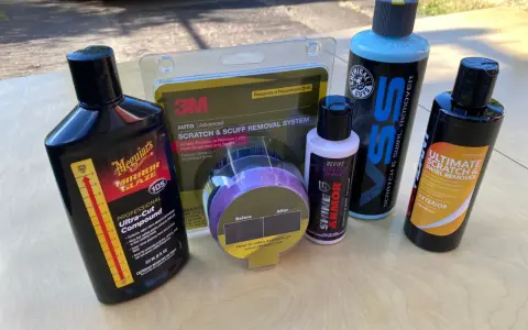 Car scratch removal products, including rubbing compound, are laid out, ready to tackle paint scratches and swirls.