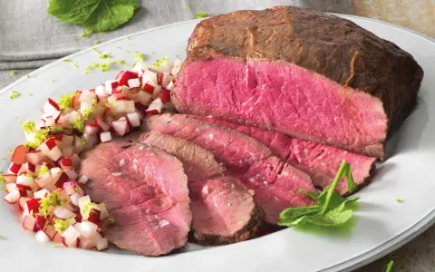 Roast beef ricetta in pentola: succulento arrosto affettato con contorno di ravanelli e scorza di lime.