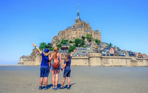 Famille en visite à Mont Saint-Michel, émerveillée par le château perché sur son îlot rocheux.