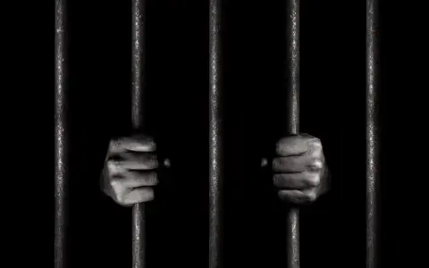 Dwie dłonie zaciskają się na zimnych prętach więziennych. Czy to jego pierwszy raz, czy już recydywista penitencjarny?