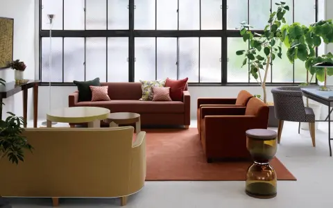 Salon moderne avec canapés confortables, tables basses et plantes vertes. Le mobilier Hurel apporte une touche d'élégance.