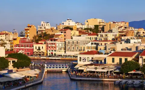 Agios Nikolaos, cosa vedere: un pittoresco porto con case colorate, ristoranti affacciati sull'acqua e un ponte pedonale.