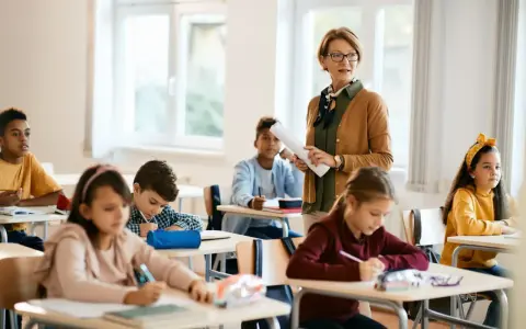Lehrerin erklärt den Schülern im Klassenzimmer, wie sie eine ausreichend note erreichen.