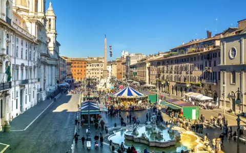 Piazza Navona a Roma a dicembre, con giostra, fontana e bancarelle.