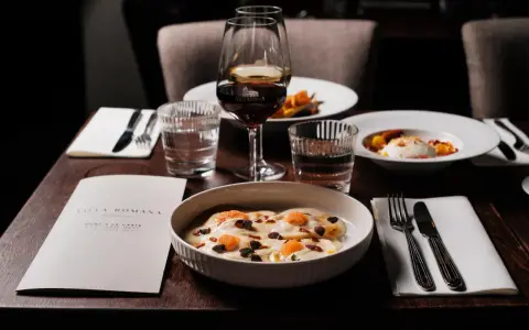 En elegant dukning med italiensk mat, vin och meny från Villa Romana, en av Stockholms bästa italienska restauranger.