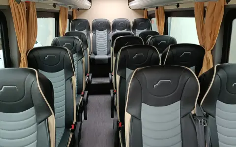 Wnętrze busa z wygodnymi, dwukolorowymi siedzeniami. Idealne do spedycji na busa, zapewniają komfort podróży.