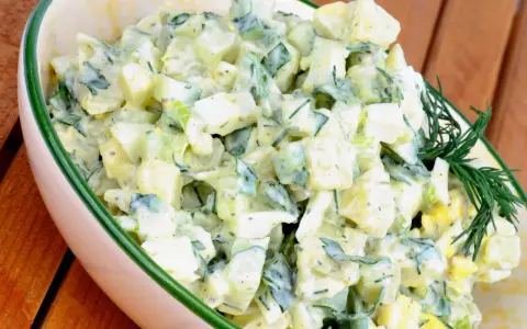 Kartoffelsalat mit Joghurt, Eiern und Gurken, garniert mit Dill. Ein cremiger und erfrischender Salat.