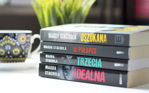 Kolejność czytania książek Magdy Stachuli: "Oszukana", "W pułapce", "Trzecia", "Idealna". Obok filiżanka.