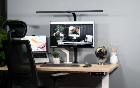 Bureau moderne avec un écran ergonomique, un ordinateur portable et une chaise de bureau.