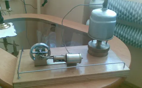 Miniaturowy silnik parowy z prądnicą, gotowy do pracy.