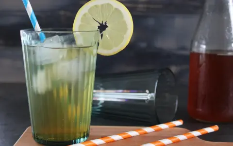 Erfrischender Eistee mit Zitrone, Eis und einem blauen Strohhalm. Perfekt, wenn du Eistee Sirup selber machen möchtest.