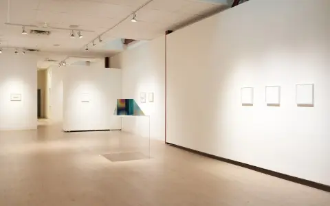 Inside the Richard Levy Gallery, minimalist artworks are displayed on white walls with polished wooden floors.