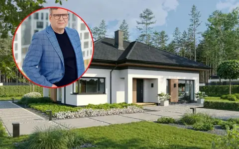 Mężczyzna w garniturze obok nowoczesnego domu. Dowiedz się, jaki jest koszt budowy domu 150m2.