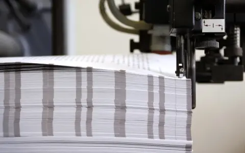 Stos papieru czeka na wykończenie. Powstają tu wydruki fine art, które zachwycą jakością.