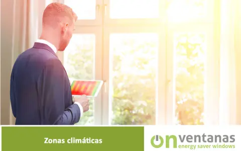 Hombre revisa tablet con mapa térmico, analizando la **zona climática** para optimizar el aislamiento de ventanas.