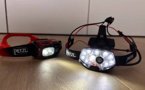 Dwie czołówki Petzl, gotowe na nocne bieganie. Jedna czerwona, druga z wieloma diodami.