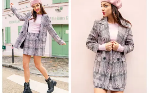 Modelka w różowym beretce i kraciastej stylizacji prezentuje się jak na **catwalku**, pozując na tle paryskiej kamienicy.