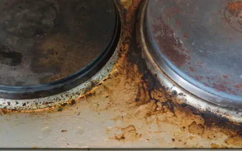 Placa de cocina con óxido y suciedad. Se necesita quitar óxido con vinagre y bicarbonato para restaurarla.