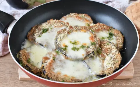 Melanzane in padella con pangrattato e formaggio filante, un piatto gustoso e facile da preparare.