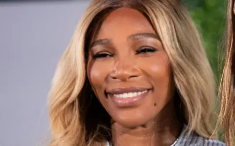 La tenista Serena Williams sonríe con su cabello rubio ondulado.