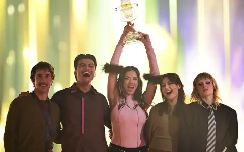 Zespół z podniesionym pucharem, świętujący zwycięstwo. Kto wygrał finał Eurowizji? Ta radosna grupa!