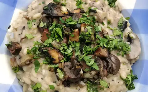 Delicioso risotto de setas cremoso, coronado con champiñones salteados y perejil fresco picado.