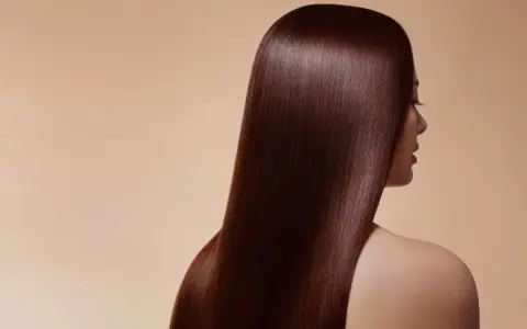 Chevelure soyeuse d'un brun profond, couleur douglas, tombant en cascade sur l'épaule d'une femme.