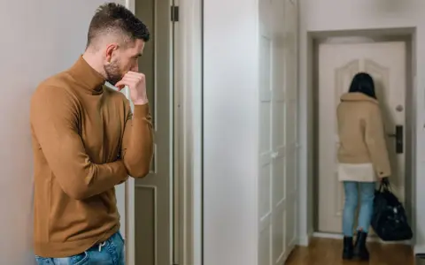 Mężczyzna w golfie zamyślony, gdy kobieta odchodzi. Jak reagować na ghosting?