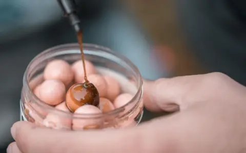 Kropla ciemnego sosu spływa na kulkę, tworząc idealny dip na karpia.