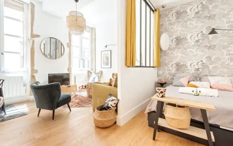 Une belle idée séparation chambre salon avec un mur décoré de nuages et un coin salon cosy.