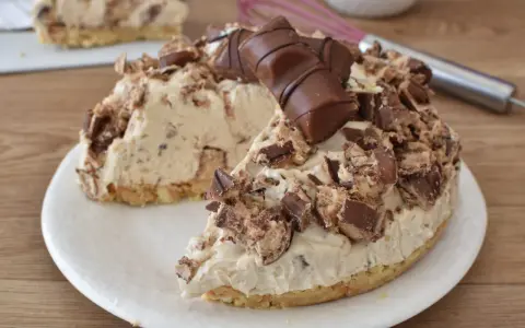 Una golosa torta Kinder Bueno, con pezzi di cioccolato e crema, pronta per essere gustata.
