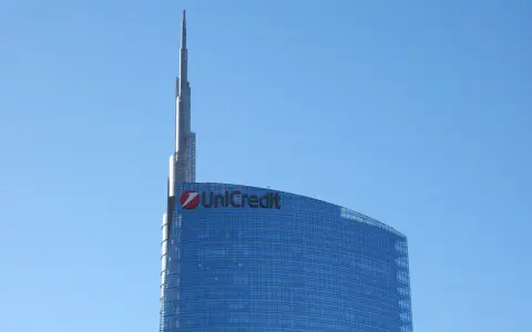 Szklany wieżowiec UniCredit z charakterystycznym logo, sięgający ku błękitnemu niebu. To symbol nowoczesności, jakby z przyszłości, niczym z wizji Aion Bank.