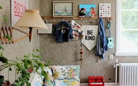 En mysig vrå med barnkläder, en gitarr och en "Be Kind"-flagga, inspirerad av Johanna Bradford blogg.