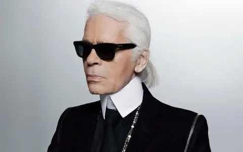 Karl Lagerfeld, jeden z najbardziej znanych projektantów mody, w charakterystycznych okularach i z siwym kucykiem.