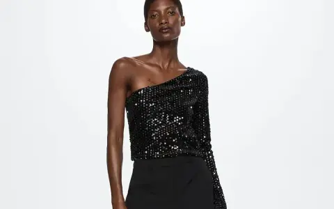Top negro de lentejuelas asimétrico, ideal para saber como vestir para un cumpleaños de noche mujer.
