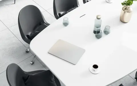 Tavolo da riunione con laptop, bicchieri d'acqua, caffè e un vaso di fiori. Ideale per un ingegnere gestionale lavoro.