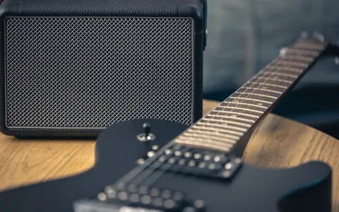 Czarna gitara elektryczna i mały wzmacniacz – to podstawa, co jest potrzebne do gitary elektrycznej, by zacząć grać.