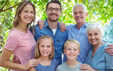 Familia sonriente, de abuelos a nietos, mostrando el factor hereditario en sus rasgos.