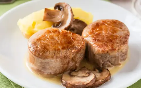 Dwa medaliony z polędwicy wieprzowej z pieczarkami i puree ziemniaczanym. Idealny polędwica wieprzowa przepis na obiad.