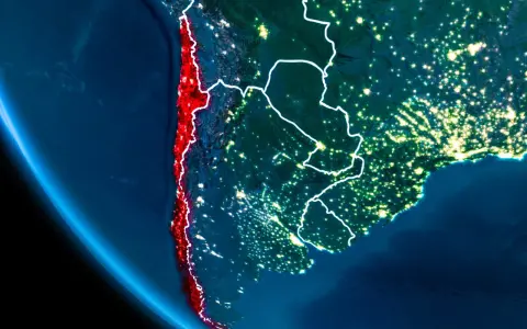 Widok z kosmosu nocą, gdzie leży Chile, podkreślone na czerwono, wzdłuż wybrzeża Pacyfiku.