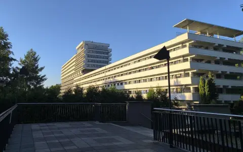 Nowoczesny budynek z tarasami, otoczony zielenią, idealny dla szukających najlepszych sanatoriów w Polsce.