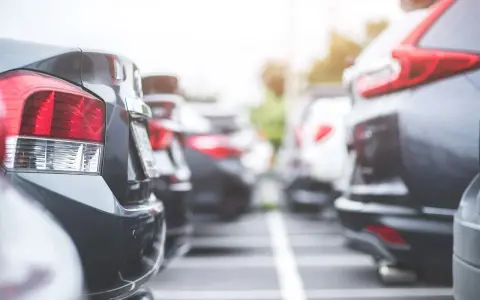 Rzędy samochodów na parkingu. Widać tylne światła i zderzaki. Czy to nowy oc?