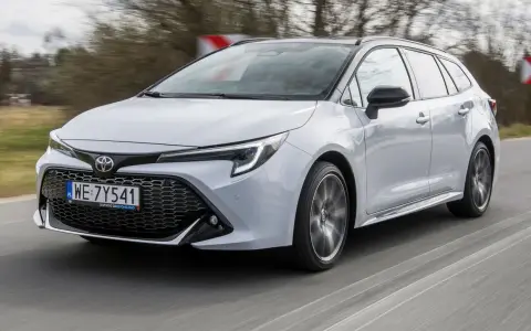 Srebrna Toyota Corolla 2.0 Hybrid w wersji kombi pędzi po drodze.