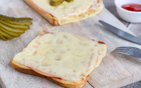 Zwei überbackene Scheiben Brot mit Schinken und Käse, dazu Gewürzgurken. Eine Karlsbader Schnitte, perfekt für den kleinen Hunger.