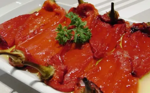 Pimientos asados en freidora de aire, tiernos y jugosos, servidos en una bandeja con perejil fresco.